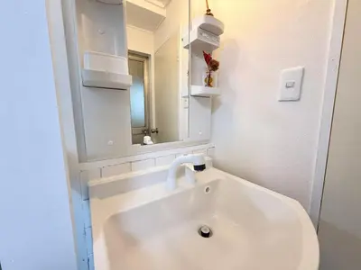 a white bathroom with a sink and a mirror at Shinjuku Waseda D2 in Tokyo