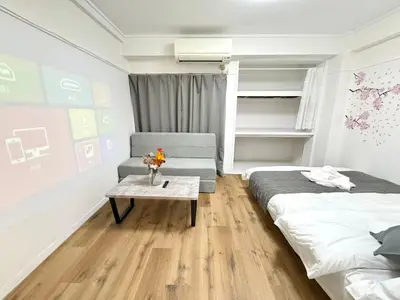 a room with two beds and a table in it at Shinjuku Waseda D2 in Tokyo