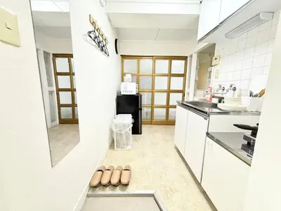 a kitchen with white cabinets and a row of brown shoes at Shinjuku Waseda D2 in Tokyo