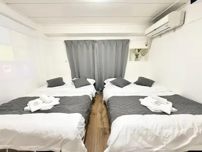 a room with three beds with towels on them at Shinjuku Waseda Cartref 3 in Tokyo