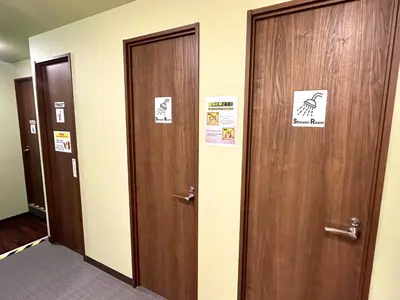 a row of doors in a hallway with signs on them at Otemachi Kamon Hotel in Tokyo