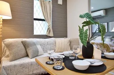 a living room with a couch and a table with glasses at BH Terrace Hirai 103 in Tokyo