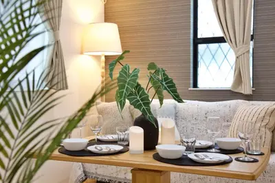 a table with plates and glasses on it in a living room at BH Terrace Hirai 103 in Tokyo