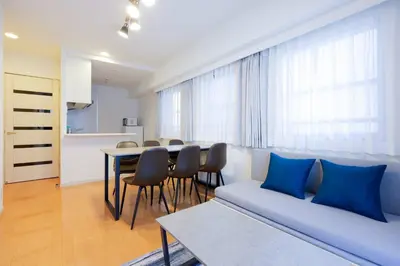 a living room with a couch and a table with chairs at \u30d7\u30e9\u30c1\u30ca\u30b3\u30fc\u30c8\u5357\u9ebb\u5e03 in Tokyo