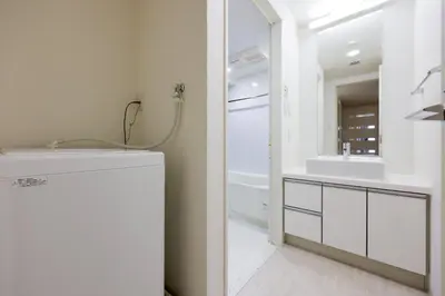 a white bathroom with a sink and a mirror at \u30d7\u30e9\u30c1\u30ca\u30b3\u30fc\u30c8\u5357\u9ebb\u5e03 in Tokyo