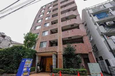 a tall brick building with the front entrance to it at \u30d7\u30e9\u30c1\u30ca\u30b3\u30fc\u30c8\u5357\u9ebb\u5e03 in Tokyo