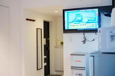 a flat screen tv on the wall of a room at NDZ102 3 min walk to station, 2 lines, Yamanote Line, explore Tokyo, high-speed Wi-Fi in Tokyo