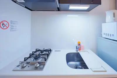 a kitchen with a sink and a stove at NDZ102 3 min walk to station, 2 lines, Yamanote Line, explore Tokyo, high-speed Wi-Fi in Tokyo