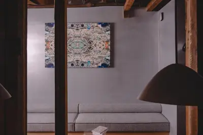 a living room with a couch and a painting on the wall at MU HEN KO Tokyo in Tokyo