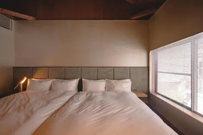 a bedroom with a large bed with a window at MU HEN KO Tokyo in Tokyo