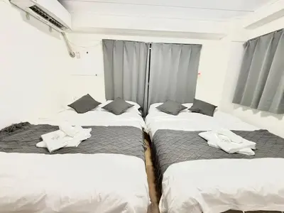 a group of three beds in a room at Shinjuku Waseda C4 in Tokyo