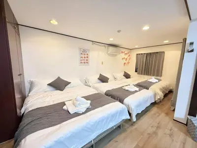 a room with three beds with towels on them at Shinjuku Waseda Bravo 1 in Tokyo