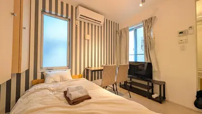a bedroom with a bed and a television at Alley House 201 in Tokyo