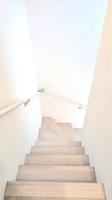 a staircase in a house with white walls and wooden floors at Alley House 201 in Tokyo