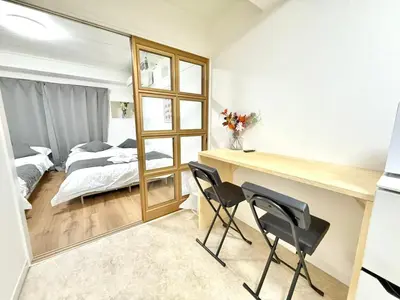 a bedroom with a bed and a desk and two chairs at Shinjuku Waseda B3 in Tokyo