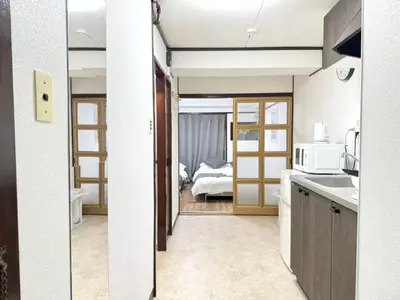 a room with a kitchen and a bedroom with a bed at Shinjuku Waseda B3 in Tokyo