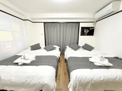 three beds in a room with white towels on them at Shinjuku Waseda B3 in Tokyo