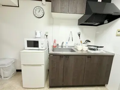 a small kitchen with a sink and a microwave at Shinjuku Waseda B3 in Tokyo