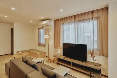 a living room with a couch and a flat screen tv at Hazama in Tokyo