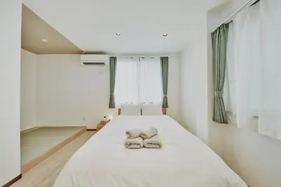 a bedroom with a bed with two shoes on it at Hazama in Tokyo