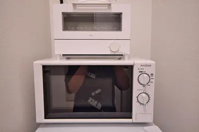 a microwave oven with a person on top of it at Mjk 201 8min Inaricho 11min Ueno Max 3 in Tokyo