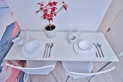a white table with plates and glasses and a potted plant at Mjk 201 8min Inaricho 11min Ueno Max 3 in Tokyo