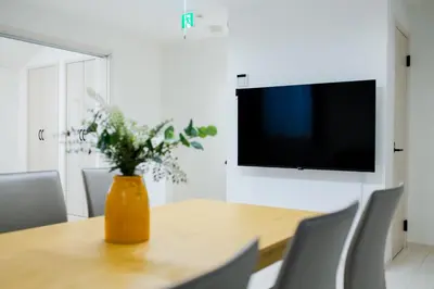 a dining room table with a vase of flowers at Oasis IKEBUKURO in Tokyo