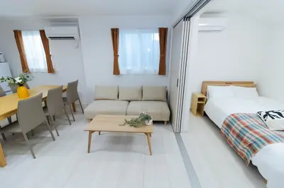 a bedroom and living room with a bed and a table at Oasis IKEBUKURO in Tokyo