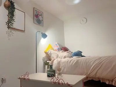 a bedroom with a bed and a table and a clock at The Tokyo Rooms in Tokyo