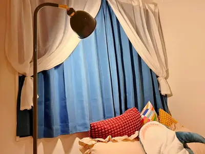 a large window with blue curtains and a lamp at The Tokyo Rooms in Tokyo