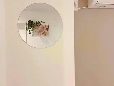 a mirror hanging on a wall with a picture at The Tokyo Rooms in Tokyo