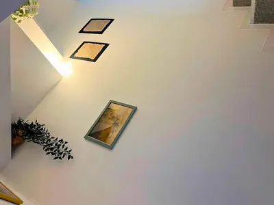 an overhead view of a staircase with a painting on the wall at The Tokyo Rooms in Tokyo