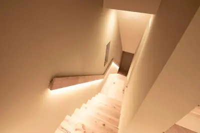 a staircase in a house with a light on the wall at Cozy 65m2 Apartment including 20m2 Loft for one month stay and longer in Tokyo
