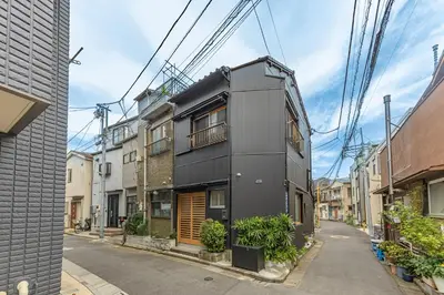 a black house on a street with wires above it at Cozy Japanese House in Sumida 2BR Direct to Narita in Tokyo