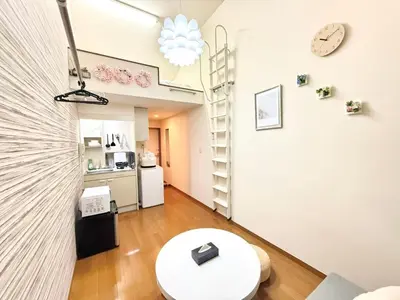 a living room with a table and a clock on a wall at Shinjuku \u9ad8\u7530\u99ac\u5834\u30c6\u30e9\u30ce\u30d0B5 in Tokyo