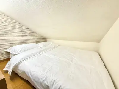 a bed with white sheets and pillows in a room at Shinjuku \u9ad8\u7530\u99ac\u5834\u30c6\u30e9\u30ce\u30d0B5 in Tokyo
