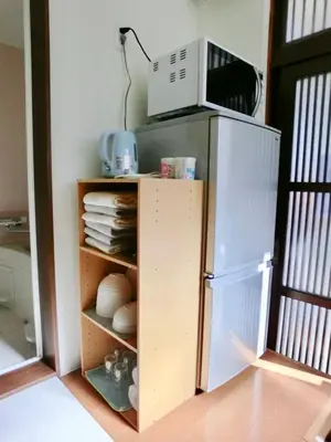 a kitchen with a microwave on top of a refrigerator at 4mins from sky tree Sumida area 3rooms Wifi in Tokyo