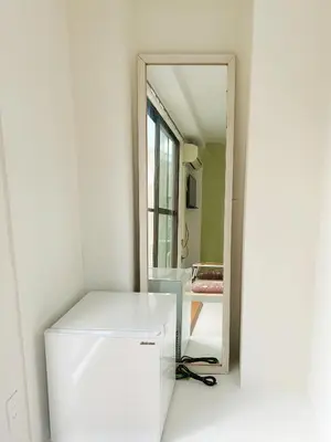 a white refrigerator in a room with a mirror at Asakusa Sakura-4F in Tokyo