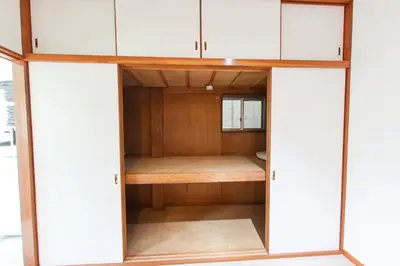 a closet with white cabinets and a wooden wall at \u30cf\u30a4\u30af\u30ec\u30b9\u30c8\u65b0\u4e2d\u91ce in Tokyo