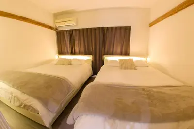 two beds in a room with a window at \u30cf\u30a4\u30af\u30ec\u30b9\u30c8\u65b0\u4e2d\u91ce in Tokyo