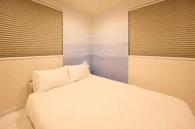 a bedroom with a white bed and two windows at WANOYADO Tokyo - Shinjuku & Shibuya 8min - 3BR 81m2House - 10ppl - Family Friendly in Tokyo