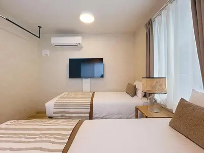 a hotel room with two beds and a flat screen tv at Viento Ikebukuro in Tokyo