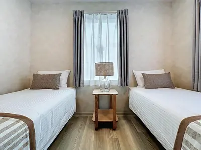 two twin beds in a room with a window at Viento Ikebukuro in Tokyo