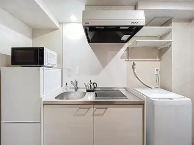a small kitchen with a sink and a microwave at Viento Ikebukuro in Tokyo