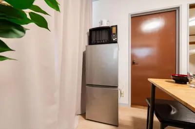 a stainless steel refrigerator with a microwave on top of it at SKY Building 301 - Skytree View Studio - Easy Airport Access in Tokyo