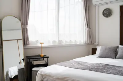 a bedroom with a bed and a window with a clock at SKY Building 301 - Skytree View Studio - Easy Airport Access in Tokyo