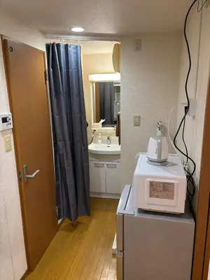 a kitchen with a microwave on top of a refrigerator at S,F, Heights - Vacation STAY 19865 in Tokyo
