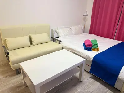 a room with two beds and a couch and a table at 2nd Narumitsu Building, Room 302 - Vacation STAY 24150v in Tokyo