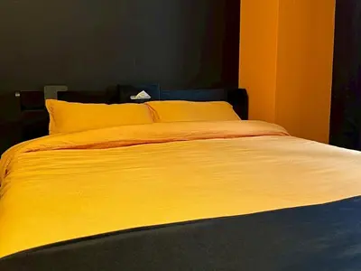 a large bed with yellow sheets and pillows at Dai2 Narumitsu Building 301 - Vacation STAY 29234v in Tokyo