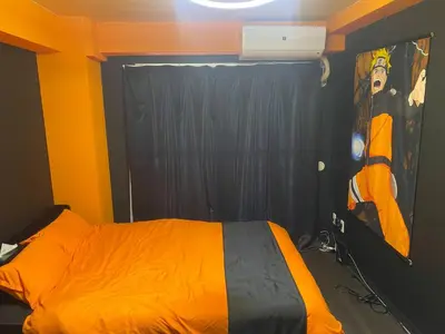 a bedroom with an orange bed with a painting on the wall at Dai2 Narumitsu Building 301 - Vacation STAY 29234v in Tokyo